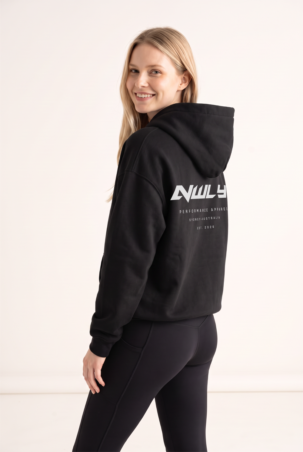 NWLY black oversized performance hoodie, rear graphic angled view