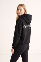 NWLY black oversized performance hoodie, rear graphic angled view
